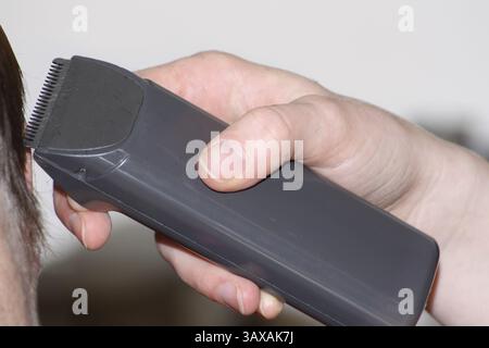 Coiffeur coupant les cheveux avec une tondeuse Banque D'Images