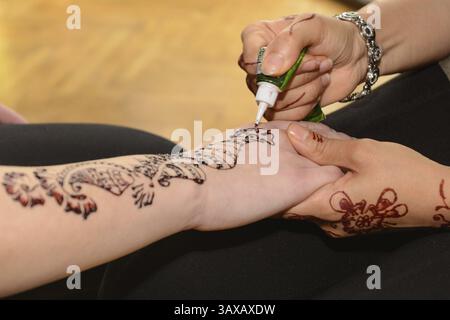 La personne fait des tatouages au henné sur les mains - gros plan Banque D'Images
