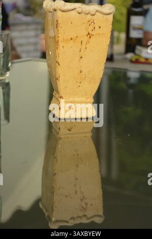 Old vase and its reflection on a table - close-up Banque D'Images