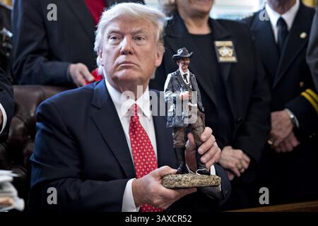 7 février 2017 - Washington, District of Columbia, États-Unis - le président américain DONALD TRUMP tient une statue qu'il a reçue en cadeau lors d'une rencontre avec les shérifs du comté dans le bureau ovale de la Maison Blanche. L’administration Trump reviendra devant la Cour mardi pour affirmer qu’elle a une large autorité sur la sécurité nationale et pour exiger le rétablissement d’une interdiction de voyager sur sept pays à majorité musulmane qui ont bloqué des réfugiés, déclenché des manifestations et remis au jeune gouvernement son premier test crucial. (Crédit image : © Andrew Harrer/Pool/CNP via ZUMA Wire) Banque D'Images