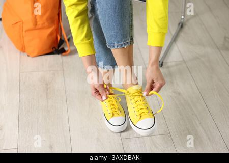 Femme essayant des baskets élégantes dans le magasin de chaussures, gros plan Banque D'Images