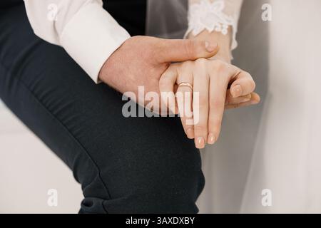 Moment de mariage intime : mains attachées avec des anneaux de mariage d'or symbolisant l'amour et l'engagement lors d'un jour spécial 182. Banque D'Images