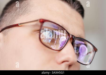 Un médecin examine une IRM du cerveau du patient. Les lunettes reflètent les résultats. Banque D'Images