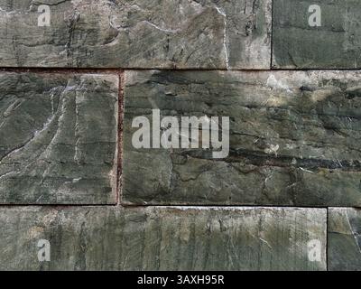 Mur en pierre de marbre vert fait de blocs rugueux inégaux. Arrière-plan abstrait Banque D'Images