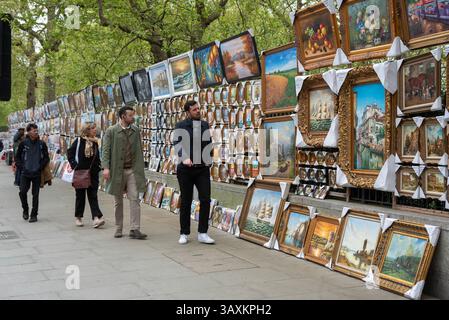 Londres, Royaume-Uni. 20 avril 2025. Les touristes se promènent devant les peintures du côté nord de Hyde Park à Londres. Une vaste sélection de peintures attend d'être vendues sur le côté nord de Hyde Park près de Piccadilly. C'est un endroit très populaire pour acheter des peintures pour les touristes et les habitants. (Photo de Krisztian Elek/SOPA images/SIPA USA) crédit : SIPA USA/Alamy Live News Banque D'Images