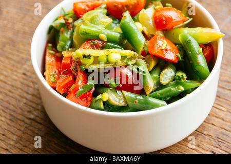Salade printanière avec haricots verts, gousses de pois mange-tout, poivron rouge et tomates cerises. Banque D'Images