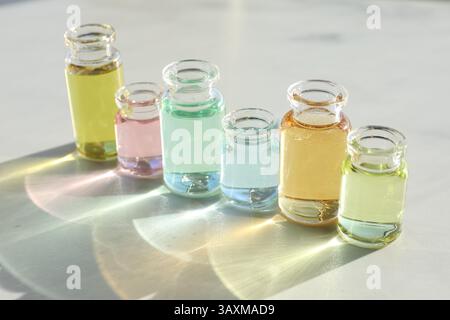 Flacons de parfum avec des huiles aromatiques sur fond clair, gros plan Banque D'Images