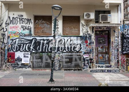 Graffiti anarchiste et anti-police sur la façade d'un squat dans le quartier d'Exarcheia à Athènes, Grèce. Banque D'Images