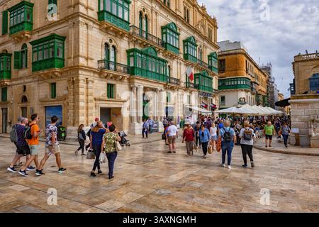 Valletta, Malte - 9 octobre 2019 : groupe de personnes, touristes sur le boulevard principal et palais Palazzo Ferreria dans le style gothique vénitien, piéton populaire Banque D'Images