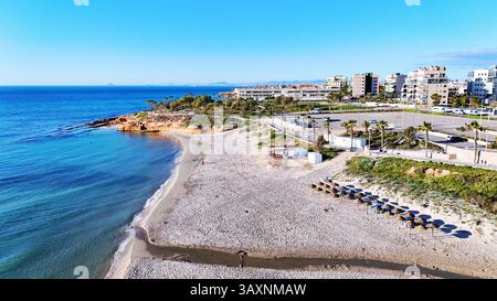 Vue aérienne de la côte de Mil Palmeras, montrant les maisons en bord de mer, promenade, plage de sable et mer Méditerranée turquoise sous ciel bleu clair Banque D'Images
