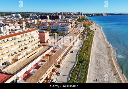Vue aérienne de la côte de Mil Palmeras, montrant les maisons en bord de mer, promenade, plage de sable et mer Méditerranée turquoise sous ciel bleu clair Banque D'Images