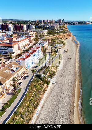 Vue aérienne de la côte de Mil Palmeras, montrant les maisons en bord de mer, promenade, plage de sable et mer Méditerranée turquoise sous ciel bleu clair Banque D'Images