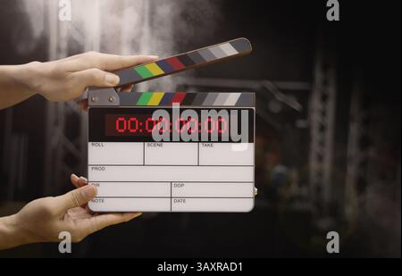 Ardoise de film numérique pour cinéaste dans le set. Main frappant timecode clapet ou ardoise de film pour la production vidéo. Numéro Digi carte de clapet ou film sla Banque D'Images