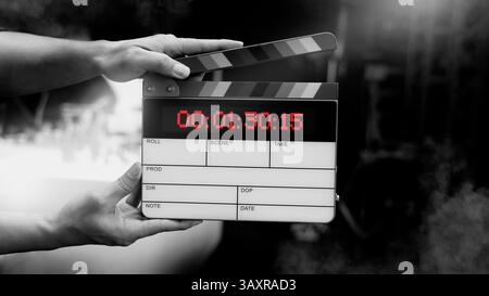 Ardoise de film numérique pour cinéaste dans le set. Main frappant timecode clapet ou ardoise de film pour la production vidéo. Numéro Digi carte de clapet ou film sla Banque D'Images