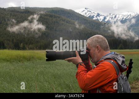 30 juin 2016 - Juneau, Alaska, États-Unis - homme faisant des photos dans Scenery Cove, Thomas Bay, Petersburg, Alaska du Sud-est. Thomas Bay est situé dans le sud-est de l'Alaska. Il se trouve au nord-est de Petersburg, en Alaska et le glacier Baird se jette dans la baie. Thomas Bay est également connu comme « la baie de la mort » en raison d'un glissement de terrain massif en 1750. Il a également gagné le nom de « pays du diable » quand, en 1900, plusieurs personnes ont affirmé avoir vu des créatures du diable dans la région. Thomas Bay est connu pour être riche en or et quartz. La faune a des orignaux, des ours bruns, des ours noirs, des écureuils, des loups, lapins, et autres communs Banque D'Images