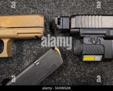 Deux pistolets : l'un avec un compensateur, lumière tactique et laser, l'autre canon standard, avec chargeur chargé à proximité. Banque D'Images