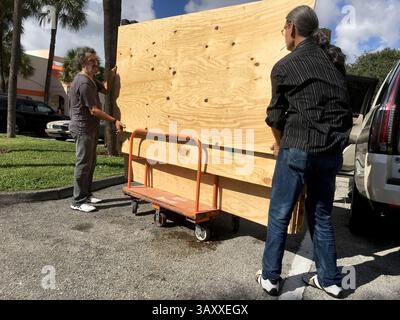 4 octobre 2016 - FL, USA - les frères Danny Delarocca, à gauche, et Gino Delarocca, à droite, tous deux de Boca Raton, en Floride, chargent du contreplaqué sur leur voiture au Home Depot à Deerfield Beach le mardi 4 octobre 2016. Alors que l'ouragan Matthew menace de plus en plus le sud de la Floride, de plus en plus de gens se dirigent vers les magasins pour s'approvisionner en fournitures. (Crédit image : © Maria Lorenzino/TNS via ZUMA Wire) Banque D'Images