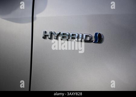 Vittsjö, Skåne, Suède. 21 avril 2025. Emblème « hybride » sur le côté d'une Toyota. Banque D'Images