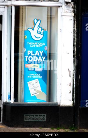 Un panneau dans une vitrine annonce la loterie nationale à Saffron Walden, Essex, Angleterre, Royaume-Uni, invitant les gens à jouer aujourd'hui. Banque D'Images