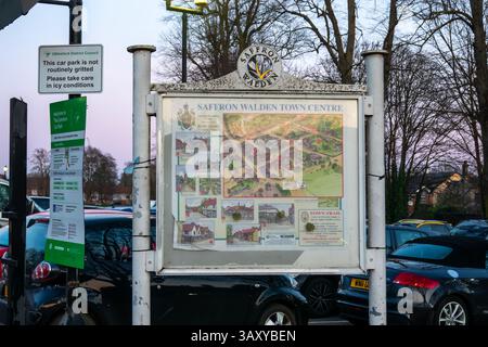Un panneau montrant une carte du centre-ville de Saffron Walden avec d'autres panneaux et des voitures garées à proximité, tourné au Royaume-Uni. Banque D'Images