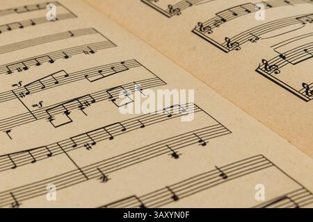 03.25.25 Lviv Ukraine Une vue rapprochée de partitions de musique avec des notations musicales complexes affichées sur un fond jaune vif, en surbrillance Banque D'Images