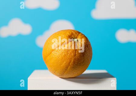 fruit orange sur fond bleu avec des nuages blancs flous Banque D'Images