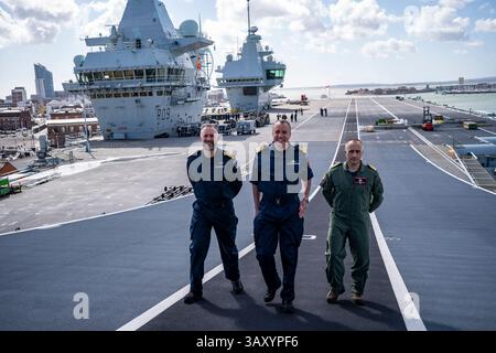 Le Capitaine Will Blackett RN, commandant du HMS Prince of Wales, à gauche, le Commodore James Blackmore RN, commandant du Carrier Strike Group, au centre, et le Capitaine Colin McGannity RN, commandant Air Group, à droite, à bord du HMS Prince of Wales amarré à la base navale HM Portsmouth, alors qu’ils préparent le porte-avions devant lui à être déployé dans le cadre du UK Carrier Strike Group pour mener une formation sur l’interopérabilité et un engagement de défense dans l’Indo-Pacifique. Date de la photo : mercredi 16 avril 2025. Banque D'Images