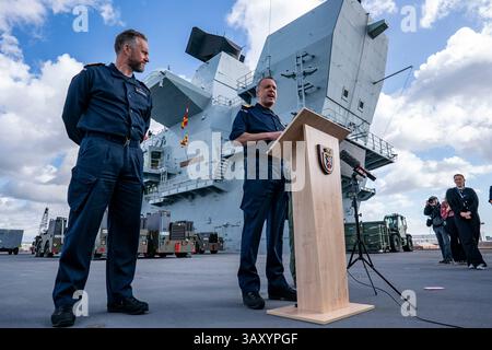 Le Commodore James Blackmore RN, commandant du Carrier Strike Group, au centre, s’adresse aux médias assemblés alors que le capitaine Will Blackett RN, commandant du HMS Prince of Wales, à gauche, regarde, à bord du HMS Prince of Wales amarré à la base navale HM Portsmouth, alors qu’ils préparent le porte-avions devant lui à se déployer dans le cadre du Carrier Strike Group britannique pour mener une formation sur l’interopérabilité et un engagement de défense dans l’Indo-Pacifique. Date de la photo : mercredi 16 avril 2025. Banque D'Images