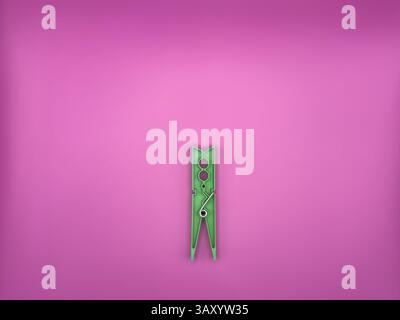 Cheville à vêtements en plastique vert moderne centrée sur l'image sur fond violet sans objets inutiles vue de dessus. Photo de haute qualité Banque D'Images