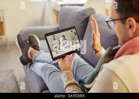 Séance de télémédecine en ligne bonjour, patient malade de sexe masculin consultation avec le médecin via la tablette informatique Banque D'Images