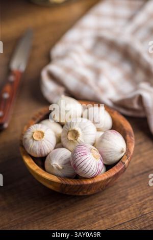 Bulbes d'ail gant solo dans un bol sur une table en bois. Banque D'Images
