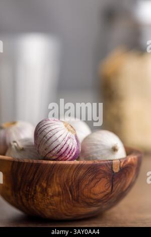 Bulbes d'ail gant solo dans un bol sur une table en bois. Banque D'Images