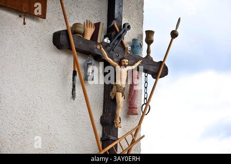 22 avril 2025, Bavière, Marktoberdorf : une croix d'Arma Christi est accrochée au mur d'une ferme. Sur une croix d'Arma Christi, des instruments de souffrance et des symboles de la crucifixion sont ajoutés à la figure de Jésus. Photo : Karl-Josef Hildenbrand/dpa Banque D'Images