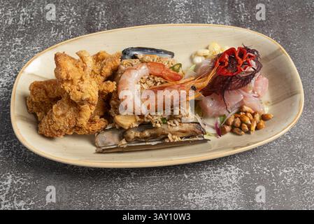 Délicieux plateau de fruits de mer péruviens présentant un délicieux mélange de poisson frit, ceviche traditionnel, riz chaufa savoureux et razo parfaitement grillé Banque D'Images