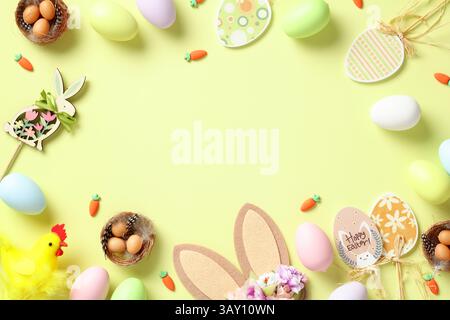 Joyeuses Pâques concept. Cadre d'oeufs de Pâques, lapin, oreilles de lapin, décorations d'oeufs en bois sur fond vert Banque D'Images