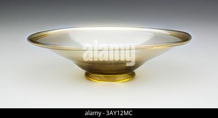 Un bol délicat et peu profond avec un bord légèrement évasé et un dégradé subtil de teintes chaudes, reposant sur un socle arrondi. L'artisanat révèle des lignes élégantes et une surface lisse et polie, lui donnant un aspect raffiné., romain, plat, 4ème / 5ème siècle après JC, verre, 2 1/4 x 8 x 6 pouces (5,7 x 20,3 x 15,2 cm), art classique avec une touche moderne réinventée par Artotop Banque D'Images