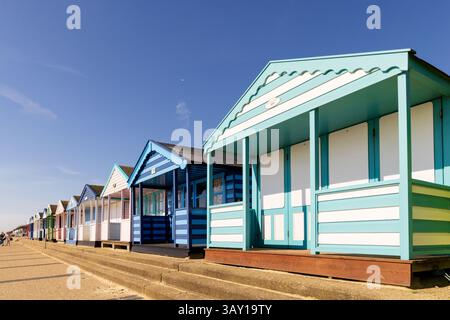 Vue sur les cabanes de plage colorées sur la promenade avec un ciel bleu à Southwold, Suffolk. ROYAUME-UNI Banque D'Images