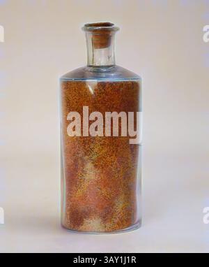 Une bouteille en verre remplie d'une substance riche et texturée aux tons chauds et terreux, coiffée d'un bouchon en liège. La surface lisse de la bouteille contraste avec les matériaux organiques à l'intérieur, créant un affichage visuellement captivant., islamique, syrien, bouteille de sable coloré, sans date, verre, sable, global : 5 7/8 × 2 3/8 pouces (14,9 × 6 cm), art classique avec une touche moderne réinventée par Artotop Banque D'Images