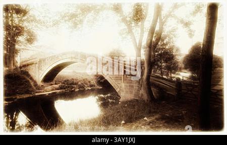 Un élégant pont en pierre arque gracieusement au-dessus d'un ruisseau qui coule doucement, encadré par des arbres luxuriants. Le paysage serein capture un sentiment de tranquillité et de beauté intemporelle, invitant à la réflexion tranquille dans ce cadre paisible., Beggar's Bridge, Glaisdale, entre 1870 et 1890, impression albumine, image : 5 × 8 3/8 pouces (12,7 × 21,3 cm), Art classique avec une touche moderne réinventée par Artotop Banque D'Images