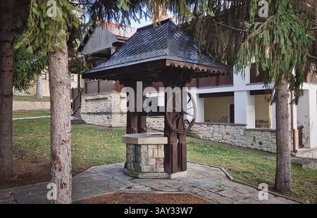Ancien puits traditionnel en bois et pierre, dans la cour du monastère de Capriana, Moldavie Banque D'Images