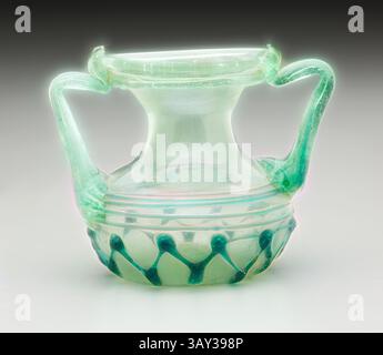 Un délicat récipient en verre avec un corps gracieusement incurvé, orné de motifs complexes et de deux poignées élégamment arquées, mettant en valeur un mélange de teintes translucides., Roman, pot à deux poignées, 4ème siècle ce, verre, 2 15/16 x 3 1/2 x 2 5/8 po ( 12,2 x 8,9 x 6,7 cm), art classique avec une touche moderne réinventée par Artotop Banque D'Images