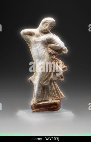 Une sculpture gracieuse, élégamment posée dans des vêtements fluides, capture un moment de mouvement serein, mettant en valeur des détails complexes et une finition polie. La pièce incarne l'art et l'artisanat, invitant l'admiration pour sa forme expressive., grec, danseuse voilée, 4ème ou 3ème siècle avant notre ère, argile, global : 9 × 3 1/2 × 1 1/2 pouces (22,9 × 8,9 × 3,8 cm), art classique avec une touche moderne réinventée par Artotop Banque D'Images