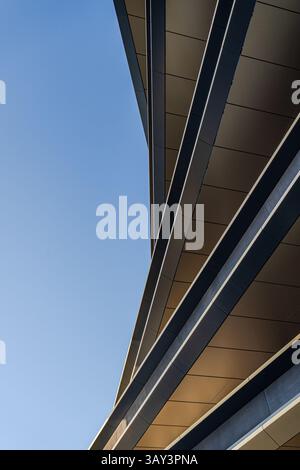 Capturant les lignes épurées et les angles vifs de l'architecture moderne, cette image met en valeur les détails complexes d'un bâtiment contemporain contre un cercle Banque D'Images