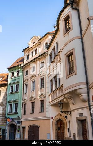 Belle rue européenne avec de charmants bâtiments historiques à Prague. Les tons pastel chaleureux et les détails architecturaux complexes soulignent l'intemporel Banque D'Images