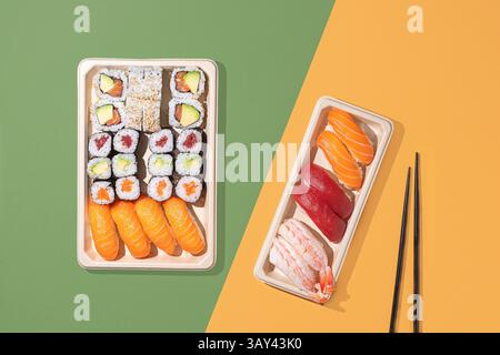 Vue de haut en bas de sushis assortis dans des plateaux respectueux de l'environnement, sur un fond moderne bicolore. Parfait pour les thèmes japonais à emporter Banque D'Images