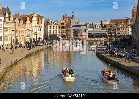 Gand, Belgique - 30/2023 : les touristes apprécient les promenades en bateau le long du canal Graslei à Gand, Belgique, flanqué de maisons de guildes historiques, avec Gravensteen Banque D'Images