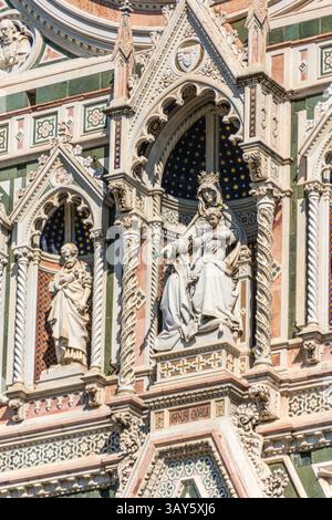 Vue rapprochée de la statue en marbre de la Vierge et de l'enfant dans une niche gothique sur la façade de la cathédrale de Santa Maria del Fiore, à Florence. Banque D'Images