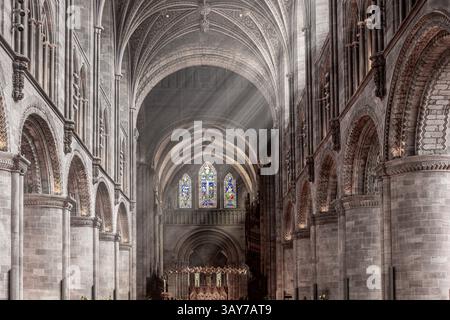 L'intérieur de la cathédrale de Hereford, Herefordshire, Angleterre Royaume-Uni. Les rayons du soleil sont visibles dans la fumée d'encens du service du dimanche matin de Pâques. Banque D'Images