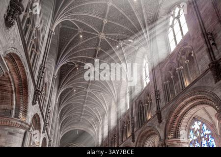L'intérieur de la cathédrale de Hereford, Herefordshire, Angleterre Royaume-Uni. Les rayons du soleil sont visibles dans la fumée d'encens du service du dimanche matin de Pâques. Banque D'Images