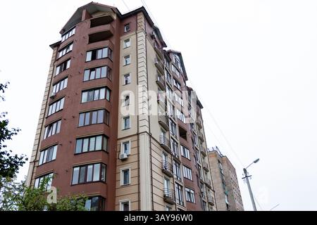 La conception architecturale unique d'un immeuble d'appartements moderne se trouve en bonne place dans une zone urbaine animée, se mélangeant avec les structures environnantes sous gra Banque D'Images